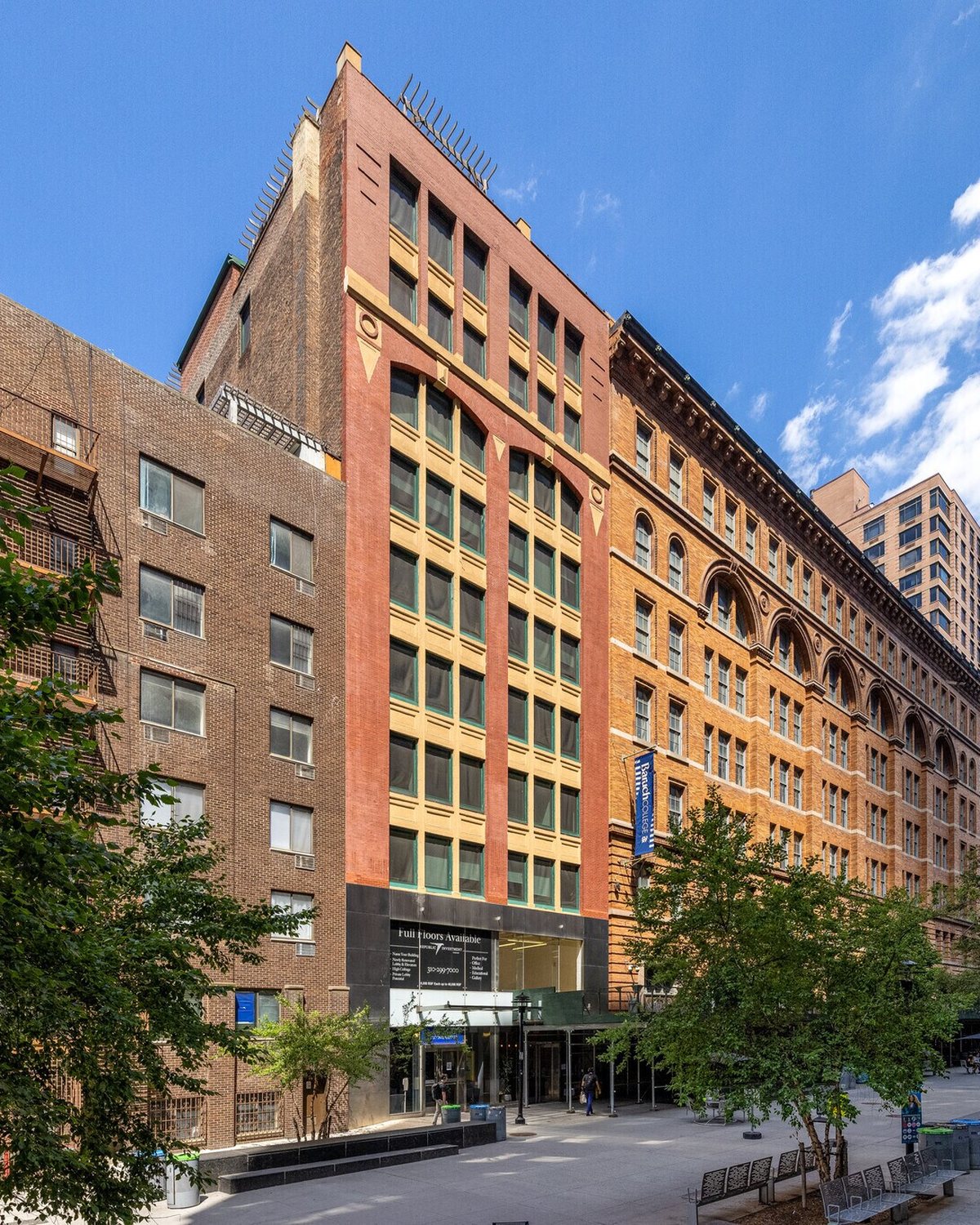 The brick facade of 137 East 25th Street rising eleven stories over the plaza